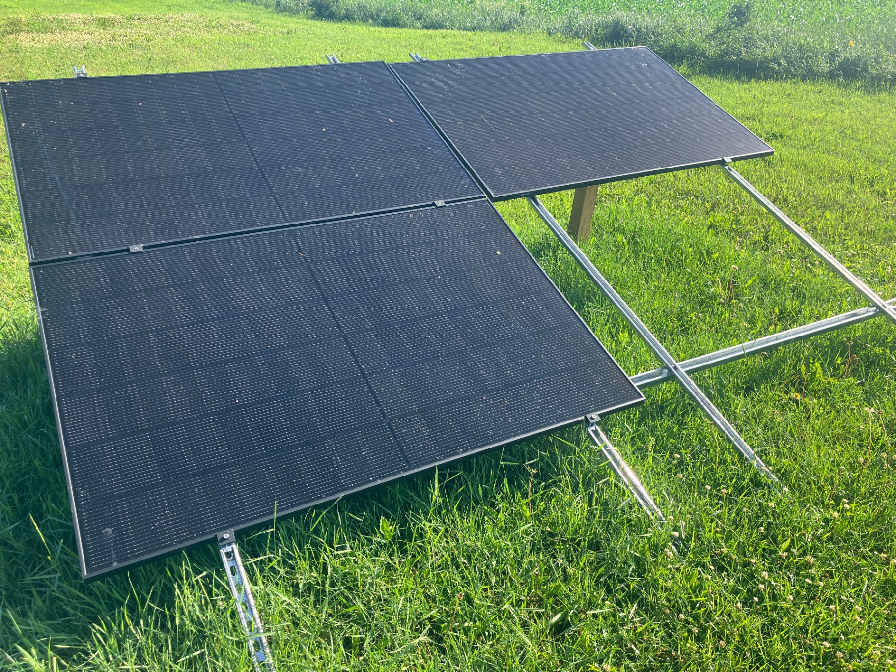 Ground-mount solar panel array installed alongside a Sparxx generator system